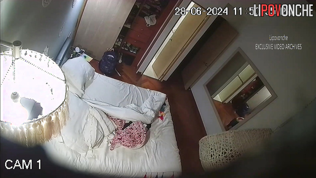 Brunette masturbates to porn in the bedroom on the bed