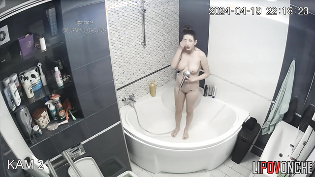 Skinny brunette with long hair washes in the bathroom