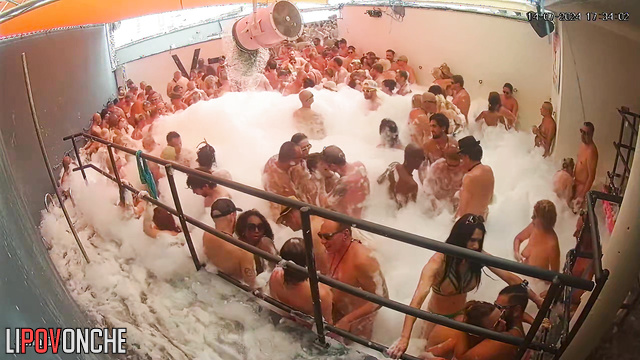 People kissing right in the foam (swinger pool party)