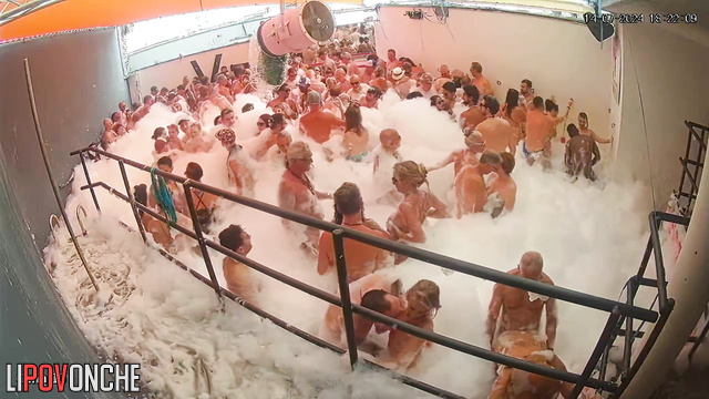 People kissing right in the foam (swinger pool party)