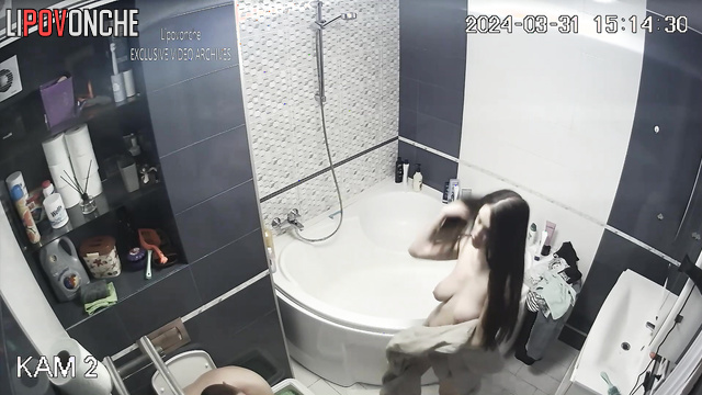 Young couple taking turns showering in the bathroom