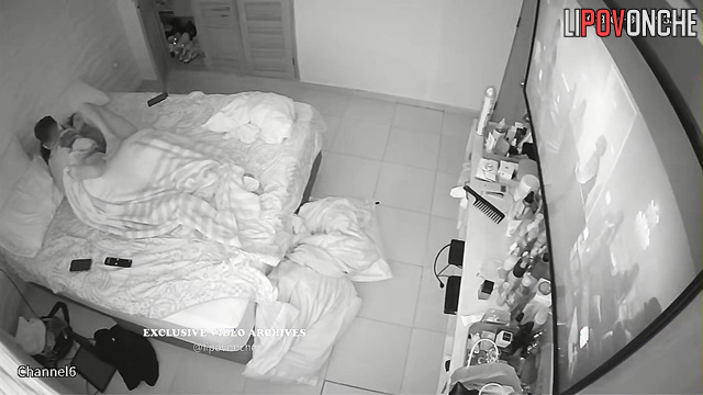 Tattooed boyfriend hugging his girlfriend in the bed