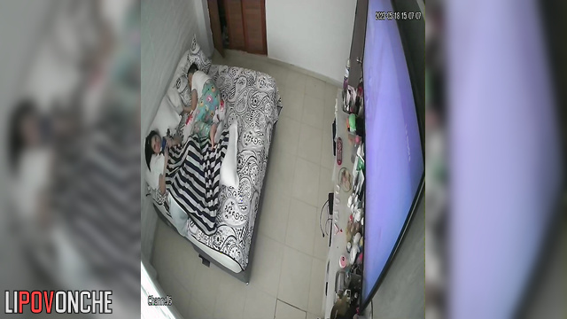 Close relatives relaxing on the bed and watching tv
