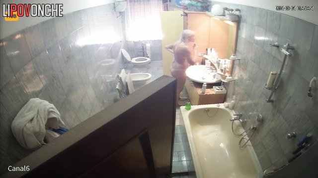 Blonde preparing for work (her husband periodically goes to the bathroom)