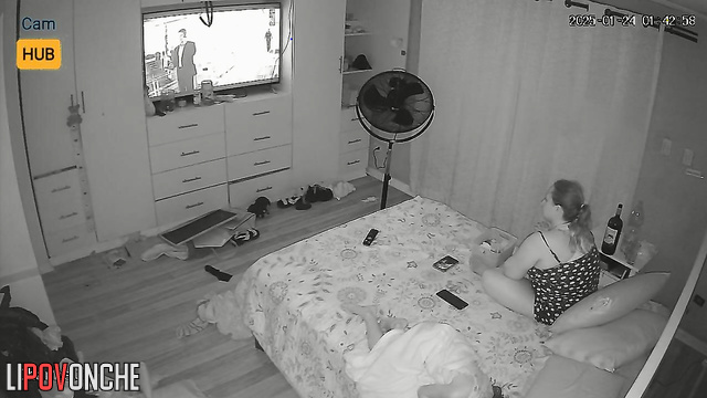 Chubby blonde watching tv and drinking wine at the same time