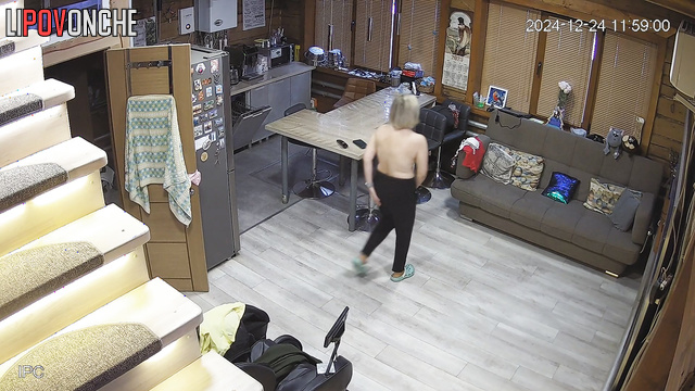 A naked blonde milf slowly gets dressed in the middle of the room while watching TV