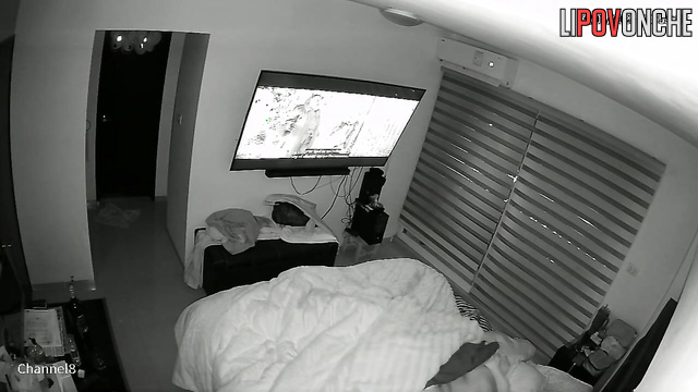 A bored wife plays with her husband's dick while he watches a movie