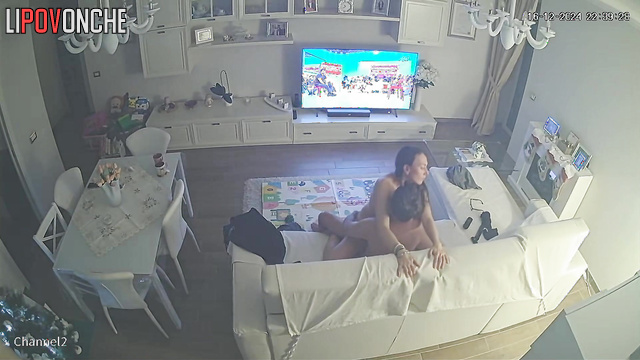 A young couple is trying out new sex positions on a large sofa