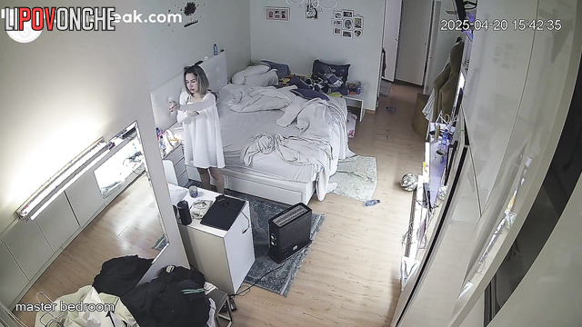Curvy blonde putting on a white dress in the bedroom