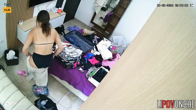 A pretty teenage girl tries on new outfits before going on a trip to a resort