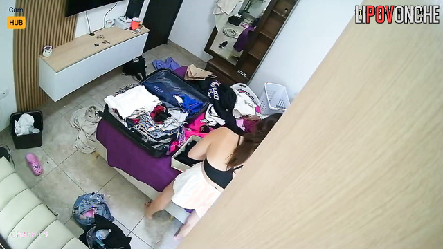 A pretty teenage girl tries on new outfits before going on a trip to a resort