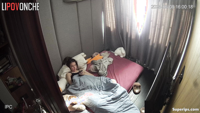 A young girl plays with her hairy pussy while watching porn on her phone