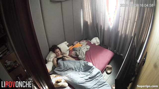 A young girl plays with her hairy pussy while watching porn on her phone