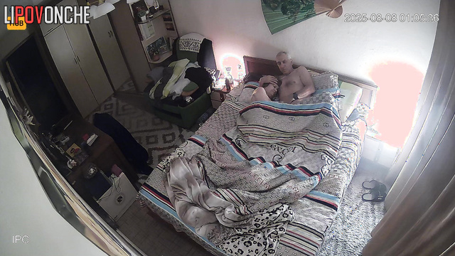 Old spouses relaxing in bed, unaware each move is captured on camera