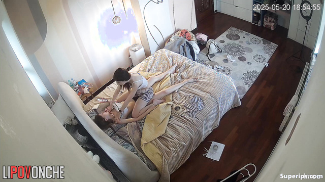 One teenager giving another a massage (one of them is topless)