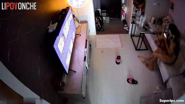 Asian couple having sex in cowgirl position and watching tv