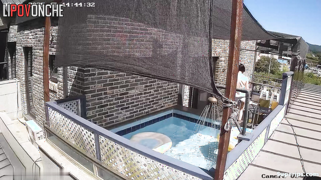 Asian couple swimming in their backyard pool, look
