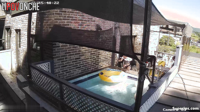 Asian couple swimming in their backyard pool, look