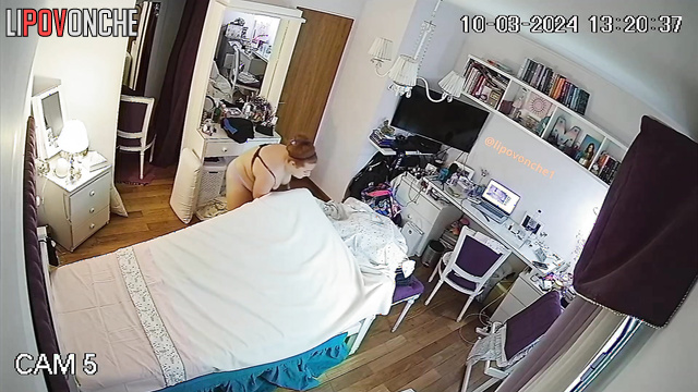 Red-haired girl in lingerie tidies up her bedroom.