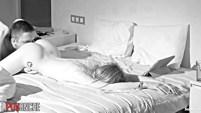 A slender, tattooed cutie is actively playing with a bearded man's big cock