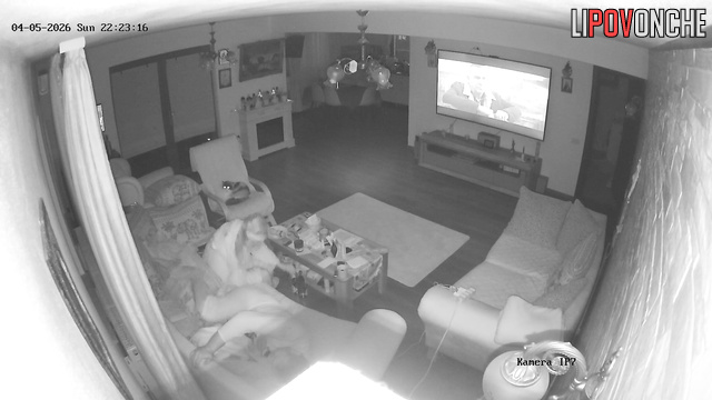 The horny milf impatiently pulls down her husband's underwear while he watches TV