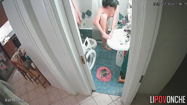 A nice brunette in glasses strips completely naked in front of the mirror
