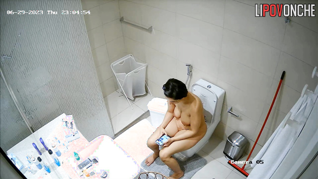 A seductive mommy completely undresses before peeing and taking a shower