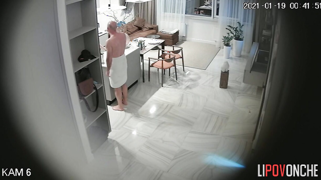 A bald man undresses his pretty wife, caresses her, and drags her into the bedroom
