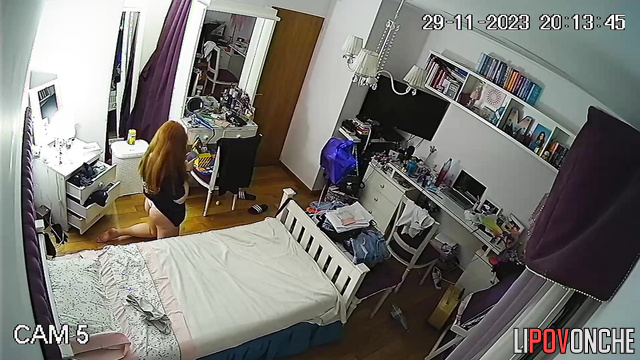 A red-haired cutie put on a striptease photo shoot right in her own bedroom