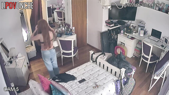 A seductive beauty is lazily strolling around the room topless