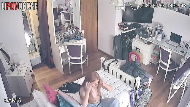 A seductive beauty is lazily strolling around the room topless