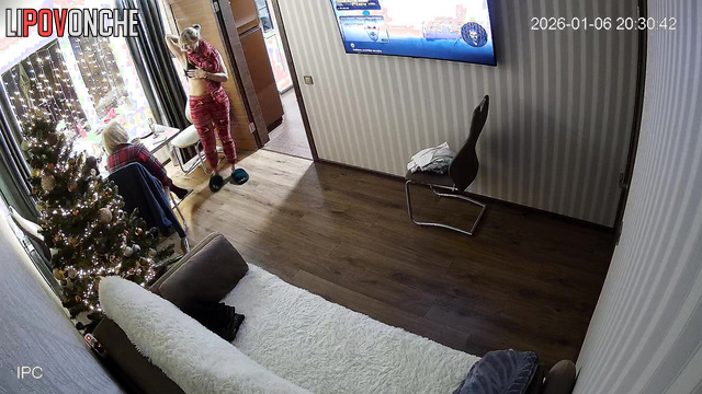 A cheerful lesbian strips down in front of her girlfriend at the New Year's table