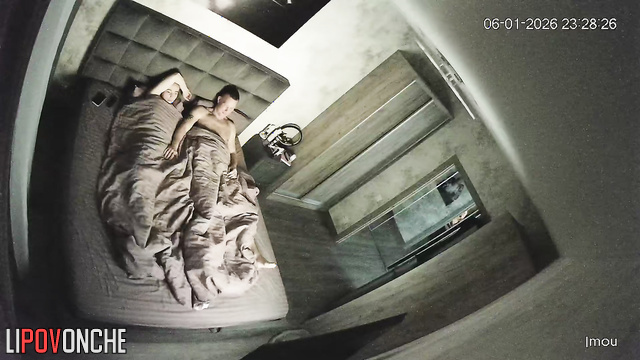 A sassy blonde gently jerks off her husband, who's lying bored in bed
