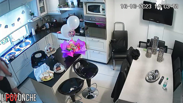 A young guy is making a pass at his redheaded girlfriend right in the kitchen