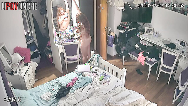 A curious beauty admires her seductive naked body in the mirror