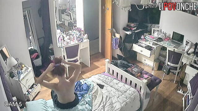 The redheaded girl undresses and gazes with interest at her firm tits in the mirror