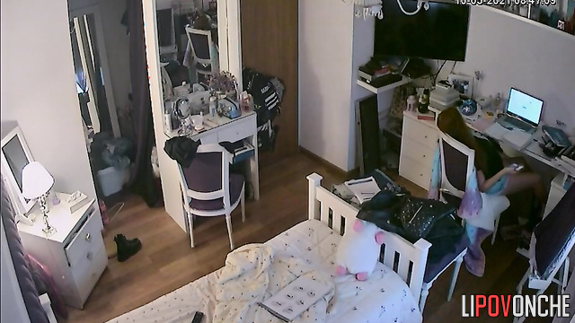 A red-haired teenage girl is taking a selfie in the mirror with her shorts pulled down