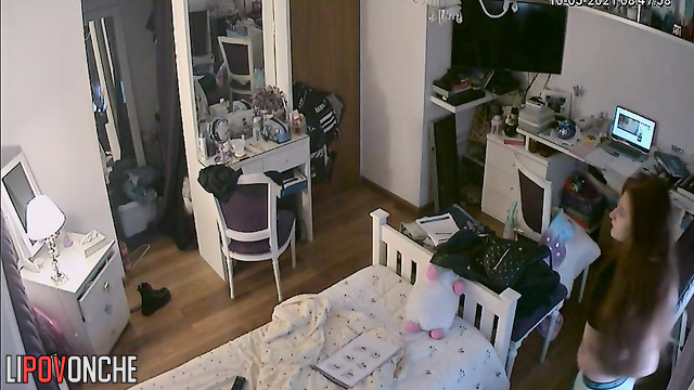 A red-haired teenage girl is taking a selfie in the mirror with her shorts pulled down