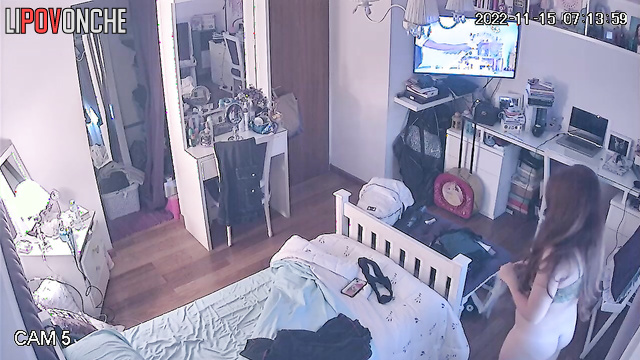 A long-haired beauty seductively takes off her panties while watching her reflection