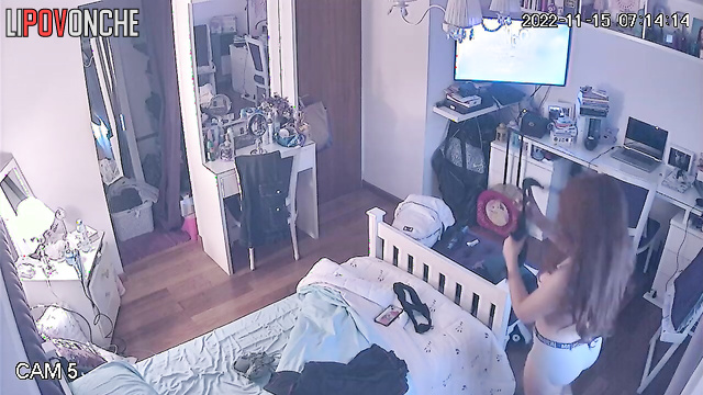 A long-haired beauty seductively takes off her panties while watching her reflection