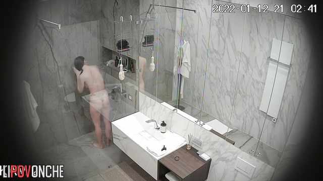 A long-haired cutie, completely naked, relaxes under the shower