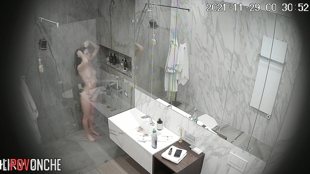 A skinny girl squeezes her bare breasts tightly as she removes the little hairs