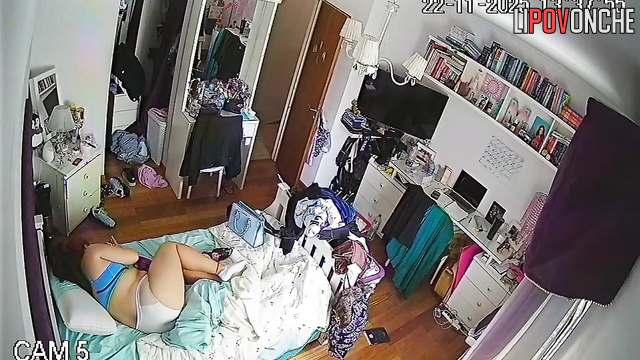 A red-haired college student is relaxing on the bed wearing only her lingerie