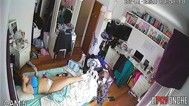 A red-haired college student is relaxing on the bed wearing only her lingerie