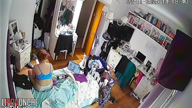 A red-haired college student is relaxing on the bed wearing only her lingerie