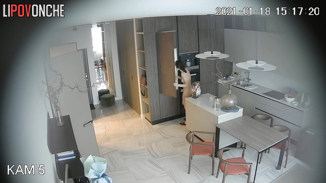A fit beauty with a hairy pussy is walking around the kitchen completely naked