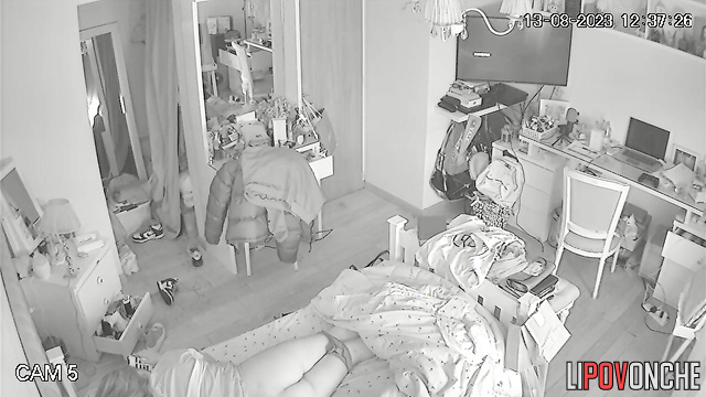 A red-haired teenage girl is lying on her bed with her panties down
