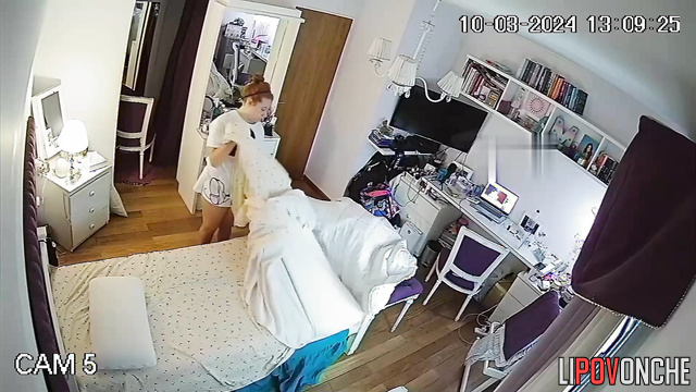 A seductive redheaded beauty in sexy lingerie straightens her bed
