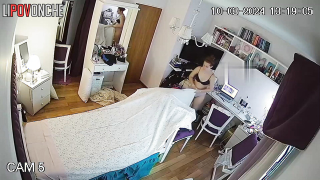 A seductive redheaded beauty in sexy lingerie straightens her bed
