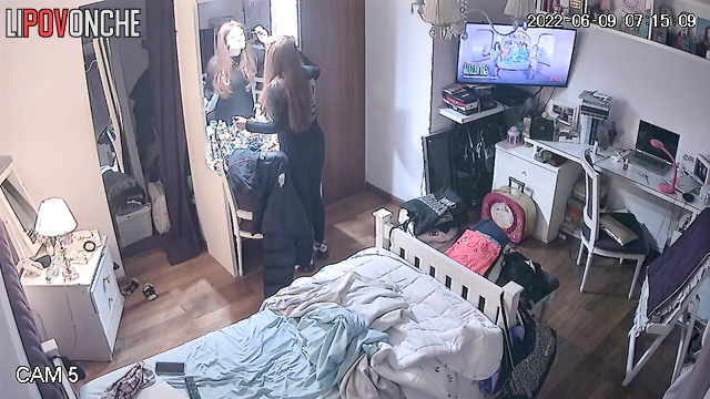 A redheaded college student strokes her breasts after taking off her bra
